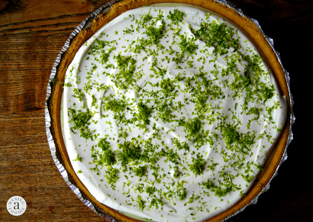 Delightful Key Lime Pie topped with fluffy whipped cream and vibrant lime zest accents.