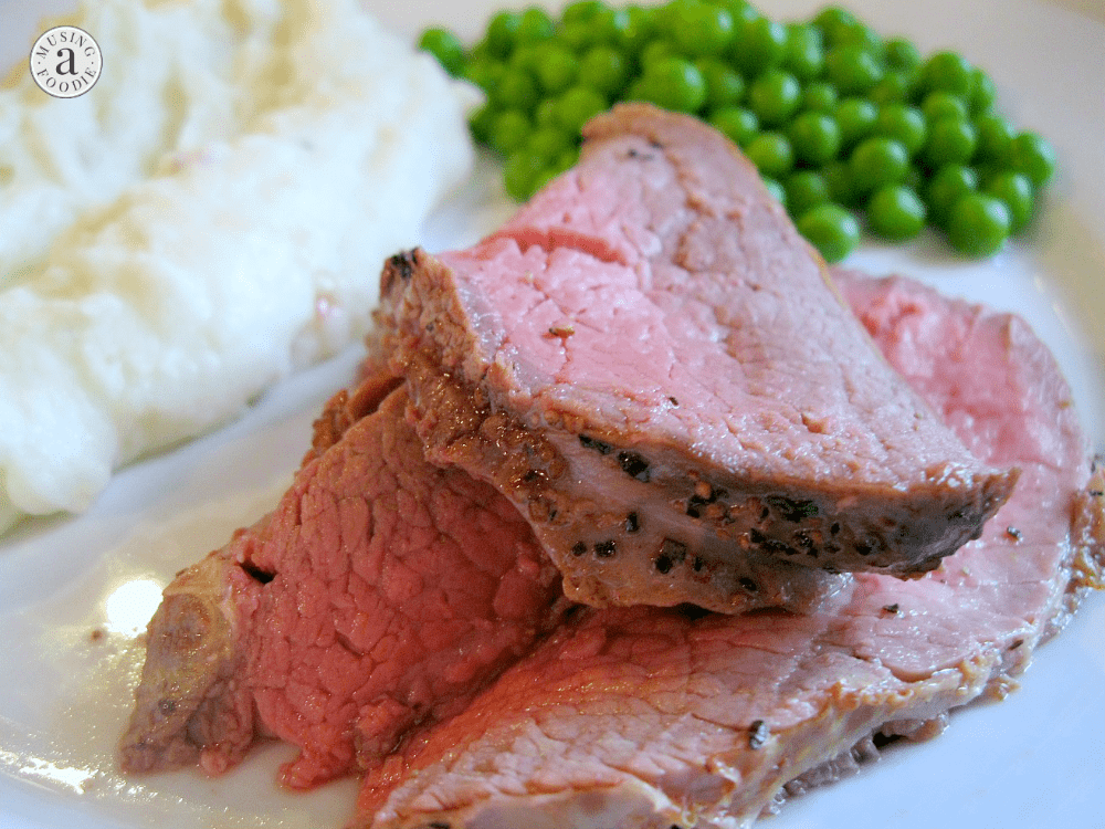 Savory roast beef with creamy mashed potatoes and vibrant green peas on a hearty plate.