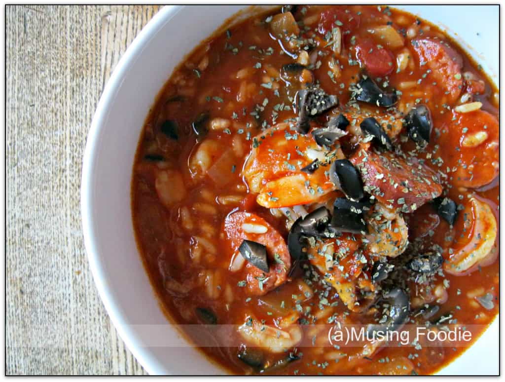 Hearty tomato soup with sausage and olives in a rustic setting. Perfect for comfort meals.