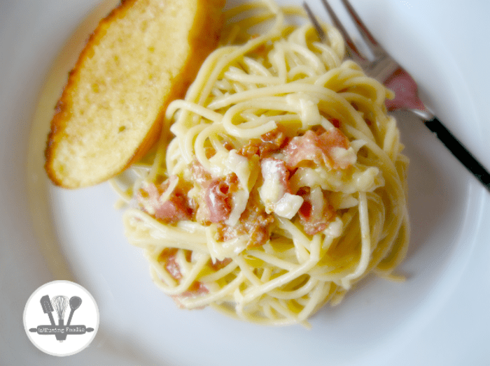 Savor creamy spaghetti carbonara paired with crispy garlic bread for a comforting meal.