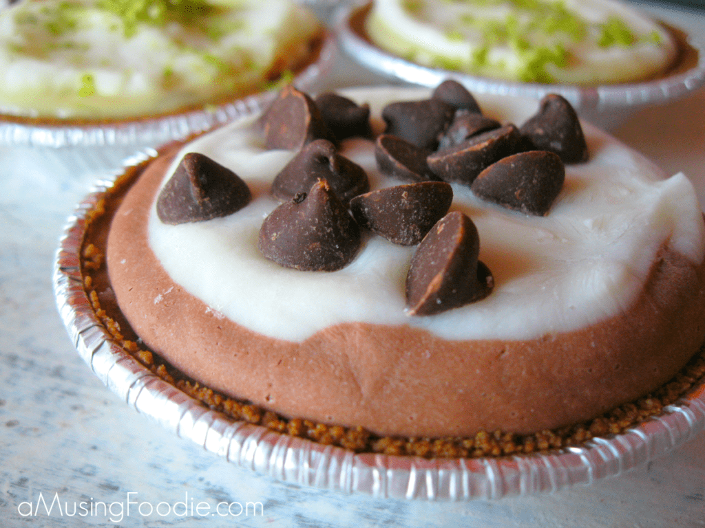 Indulgent chocolate cream pie topped with whipped cream and mini chocolate chips in an aluminum tin.