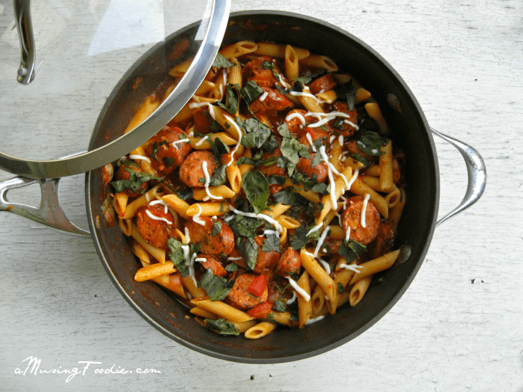 Delicious penne pasta in savory tomato sauce with meat and fresh basil.