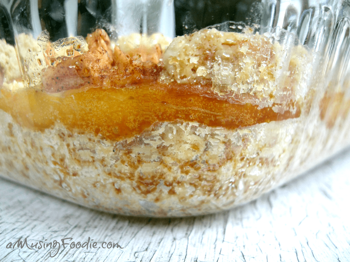 Delicious layered fruit and cream dessert with granola topping in a glass container.