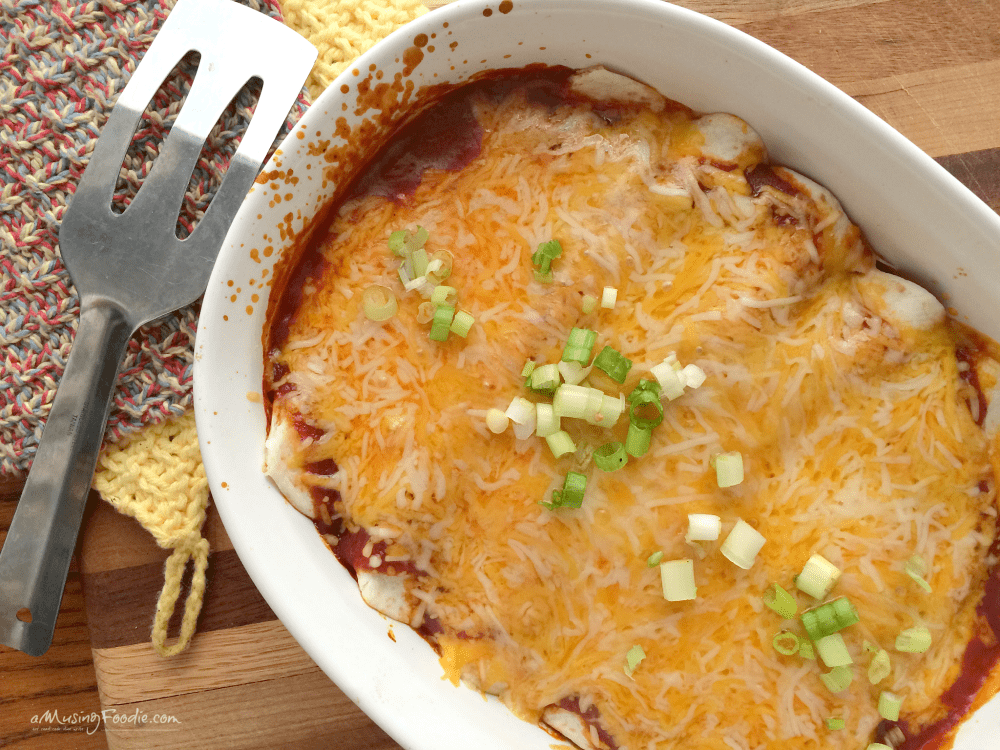 Cheesy barbecue chicken enchiladas with melted cheese and fresh green onions.