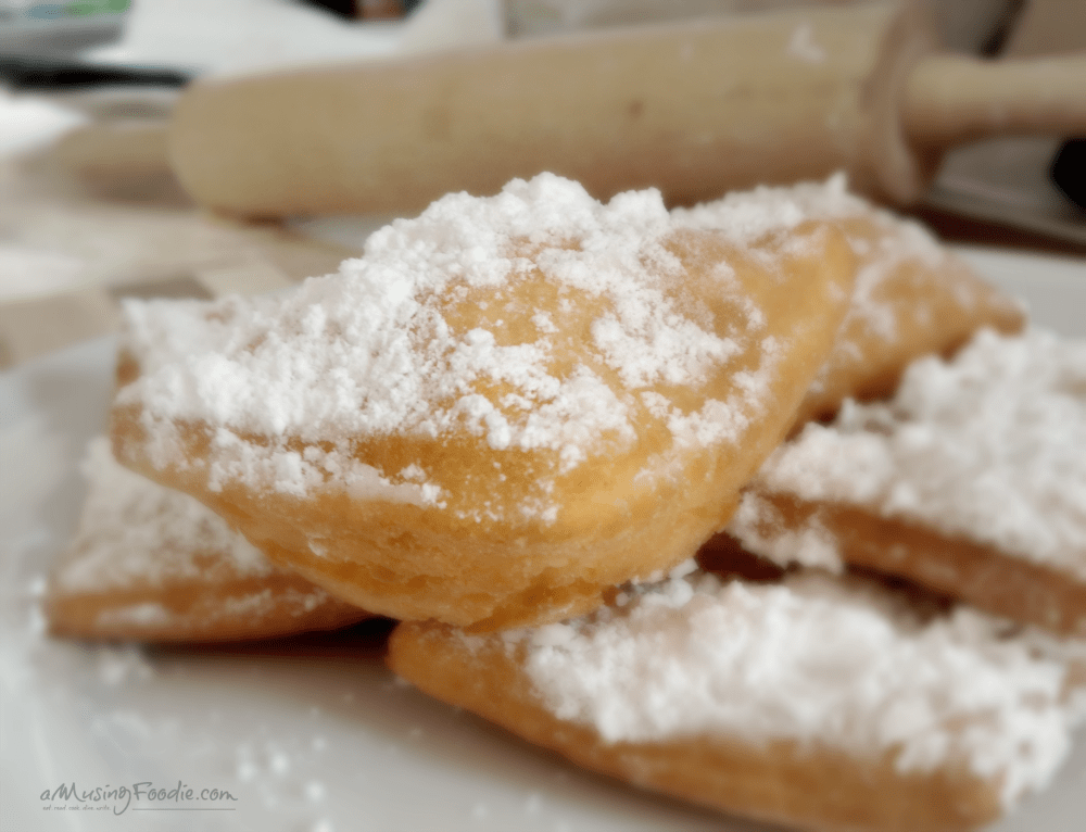 Freshly made beignets topped with powdered sugar, a homemade New Orleans delight.