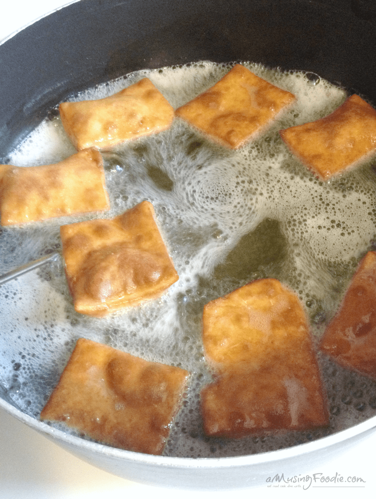 Crispy golden-brown fried dough cooking in bubbling oil, perfect for indulgence and nostalgia.