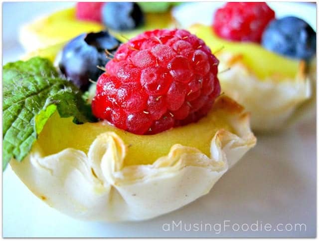 Delicious berry-topped custard tartlets in golden pastry shells, perfect for dessert lovers.
