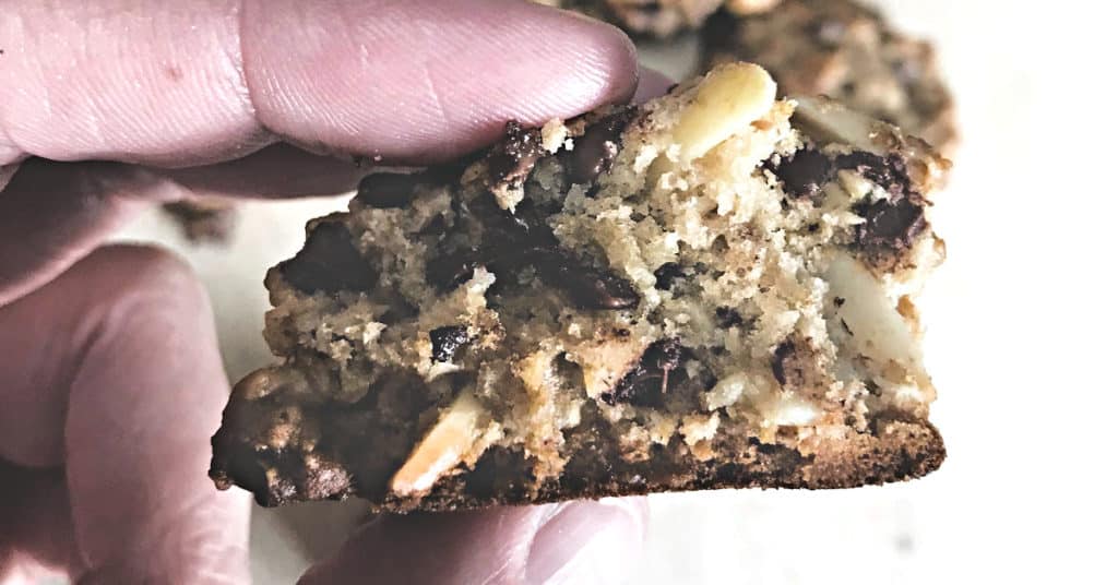 Close-up of a chewy oatmeal chocolate chip cookie with almonds, showcasing its rich texture.