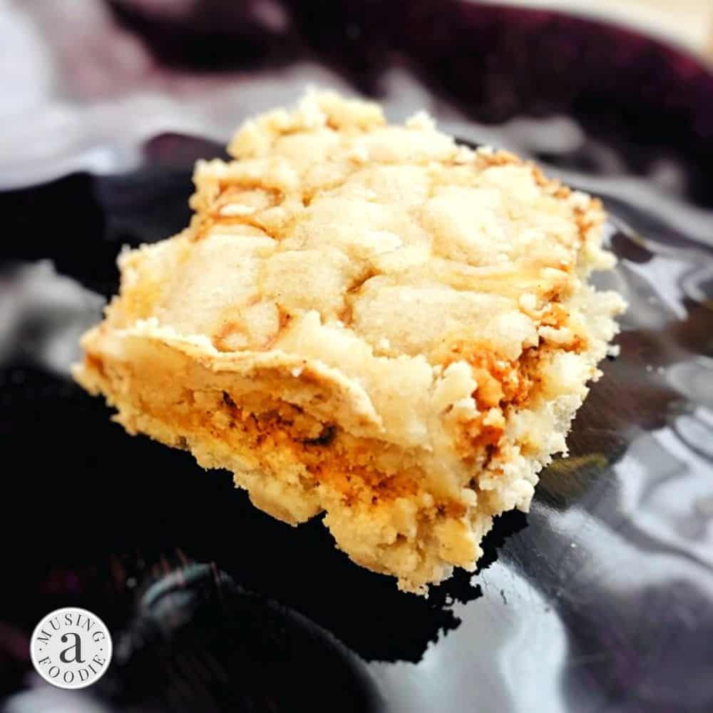 Gluten-free pumpkin cheesecake bars on a glossy plate, perfect for fall indulgence.