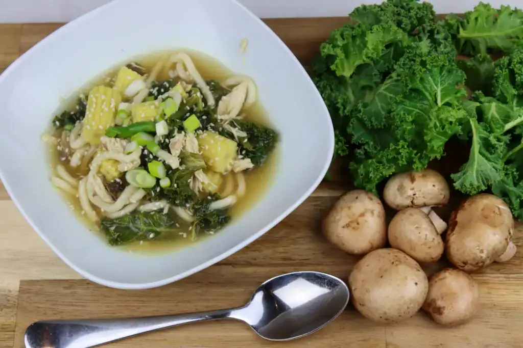 kale mushrooms and udon soup in bowl
