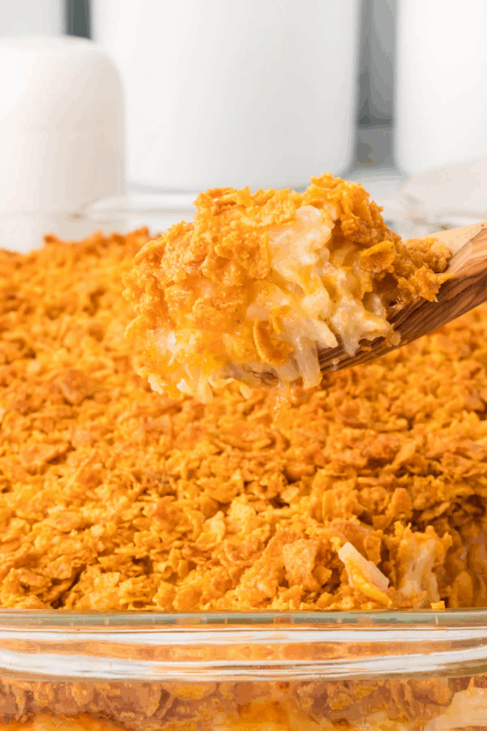 Hash Brown Casserole – aka Funeral Potatoes on wooden spoon Close up