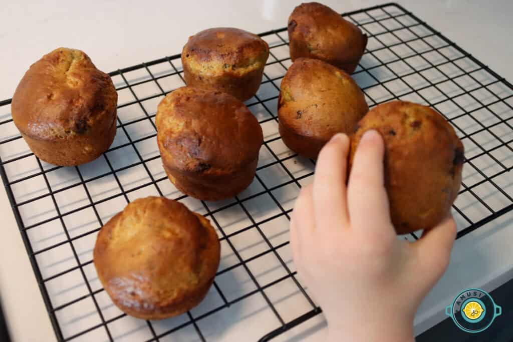 Kid’s hand grabbing golden banana muffin