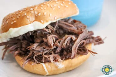 shredded beef sandwich on a sesame seed bun