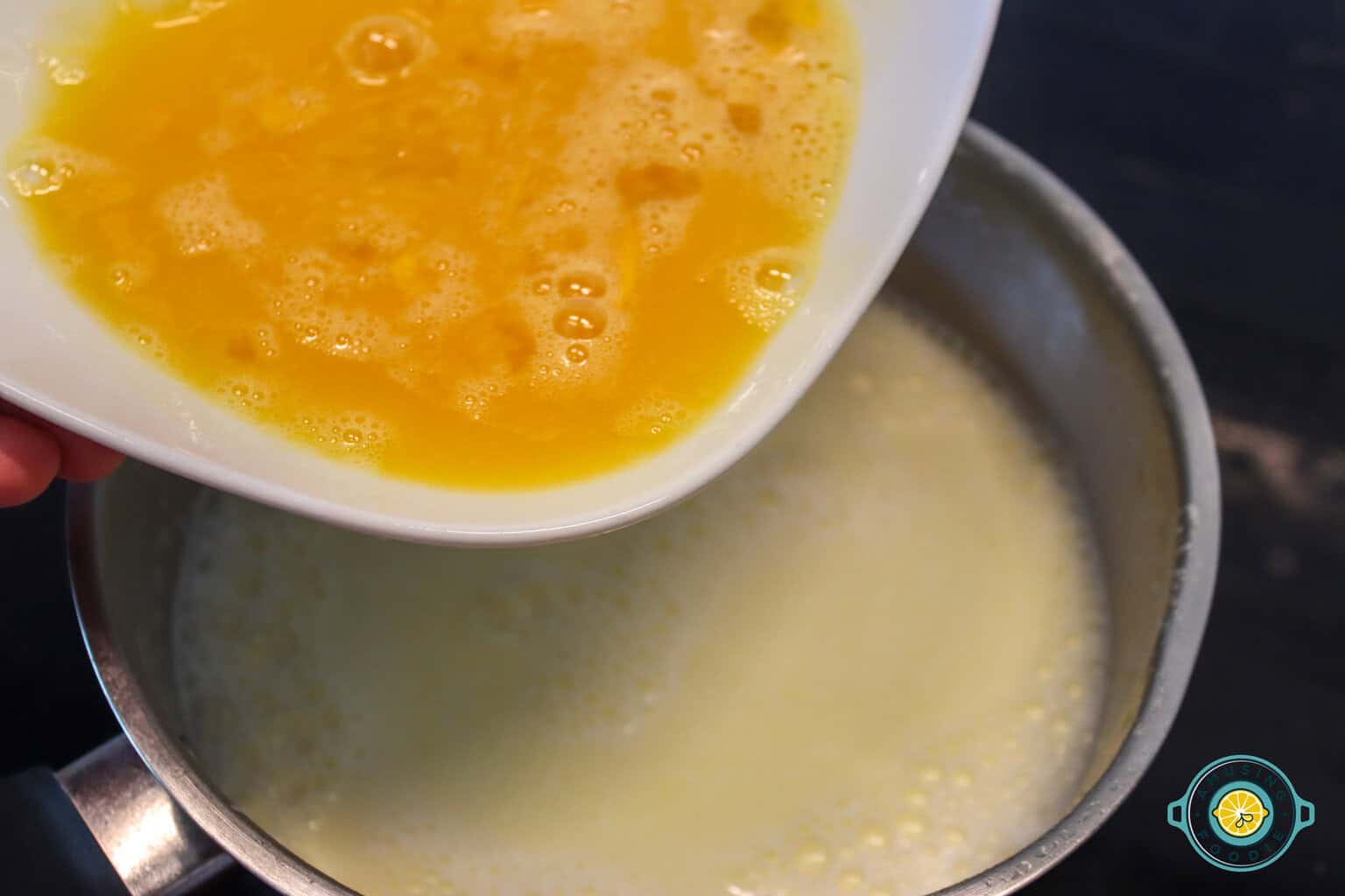 pouring egg on hot milk