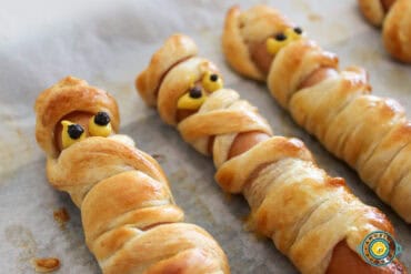 Three mummy hotdogs on parchment paper