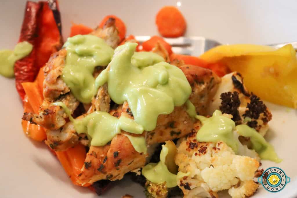 Chicken and veggies with avocado sauce on top