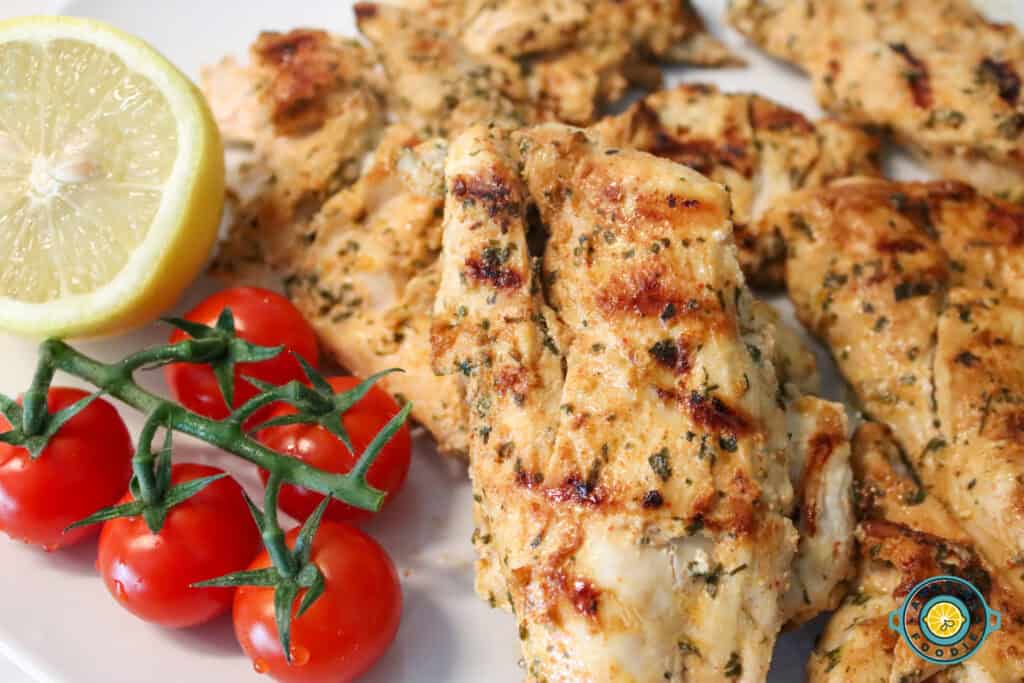 Chicken on plate with lemon and cherry tomatoes