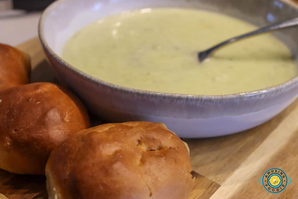 Soft dinner rolls with potato leek soup on side close up