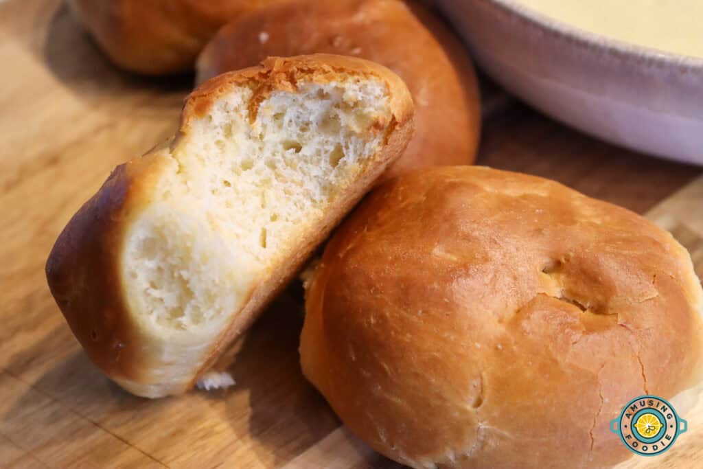 Soft golden-brown dinner roll with a bite