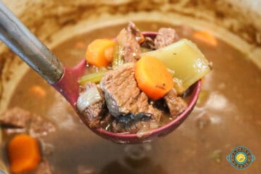 ladle filled with hearty Irish Guinness beef stew close up