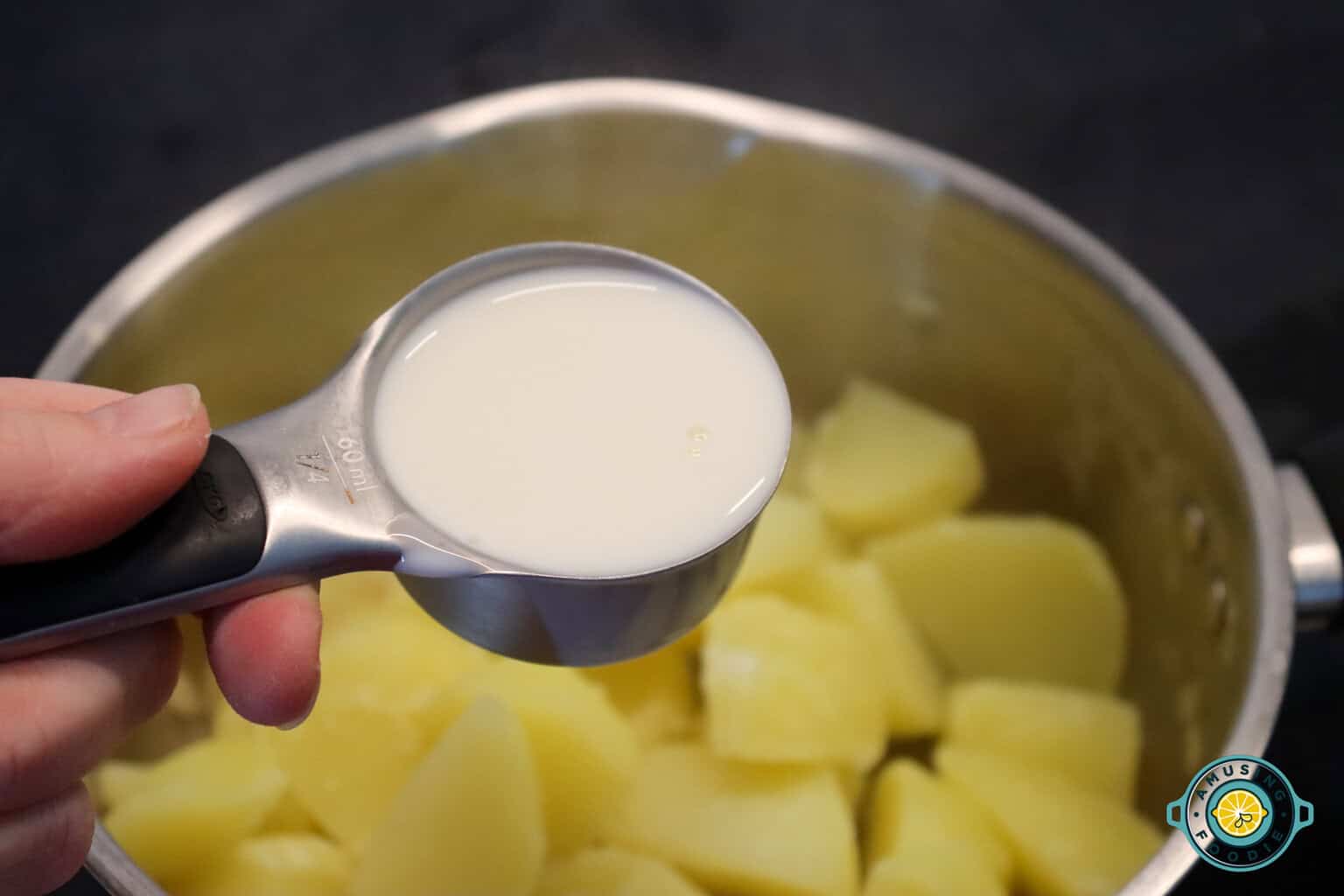 adding milk to mashed potato