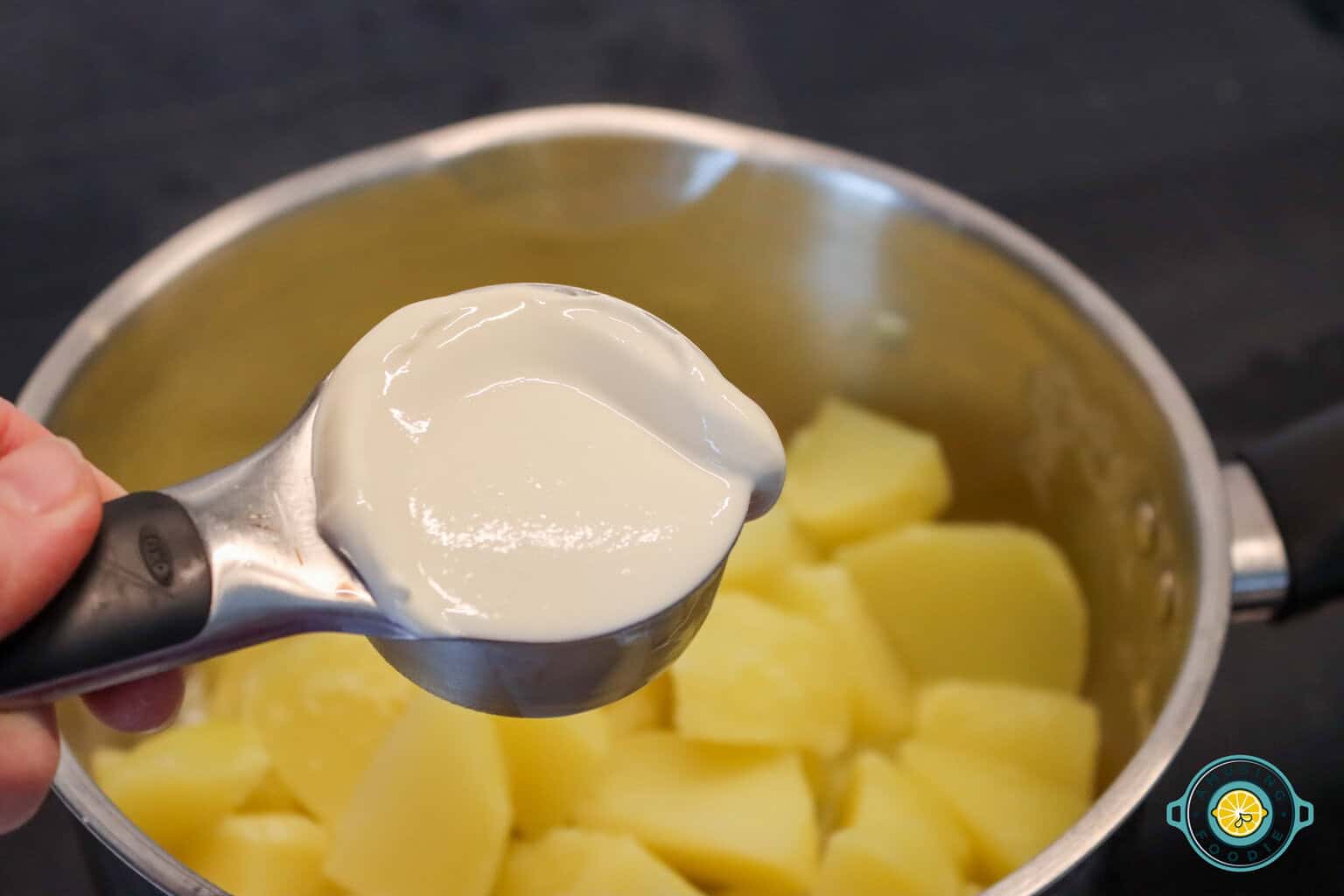 adding sour cream on mashed potatoes